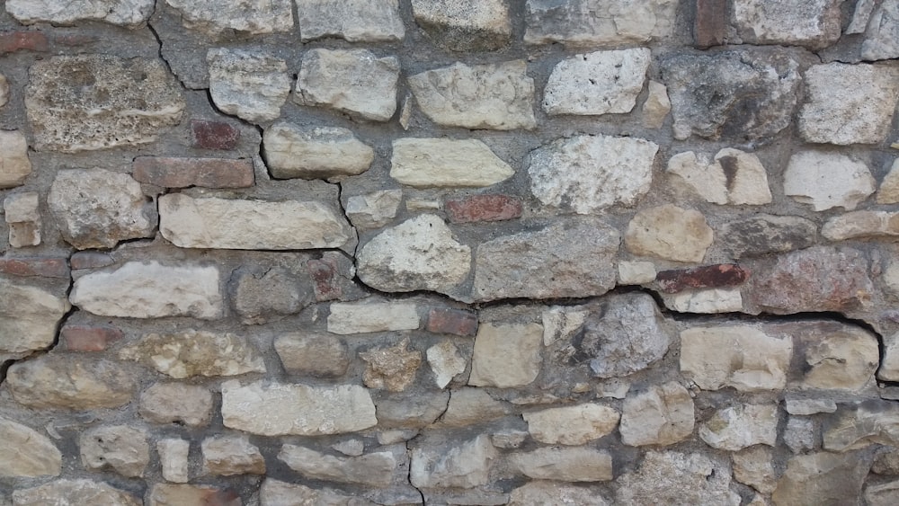 a close up of a stone wall with a clock on it