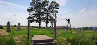 A serene memorial garden with flags gently waving in the breeze under a bright blue sky.