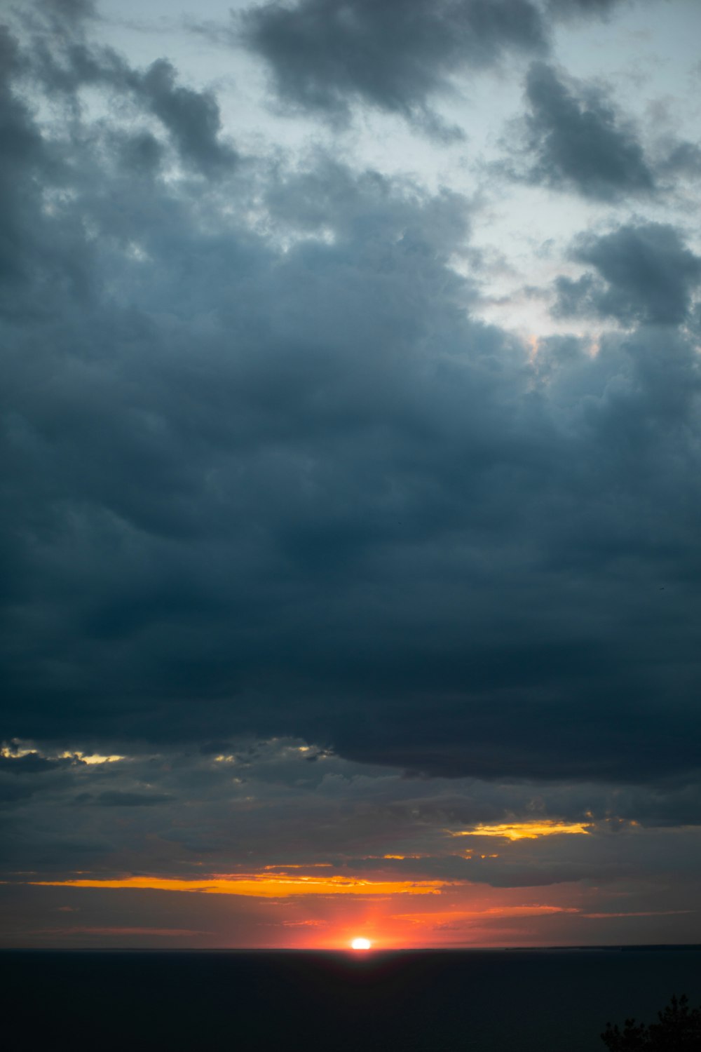 the sun is setting over the horizon of a large body of water