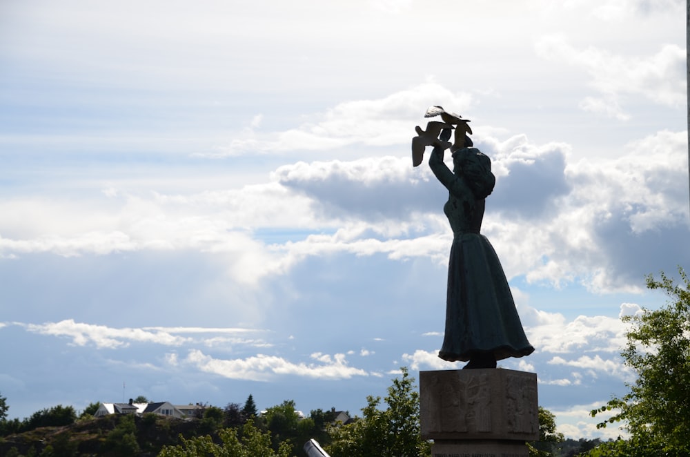 a statue of a woman holding a bird in her hand