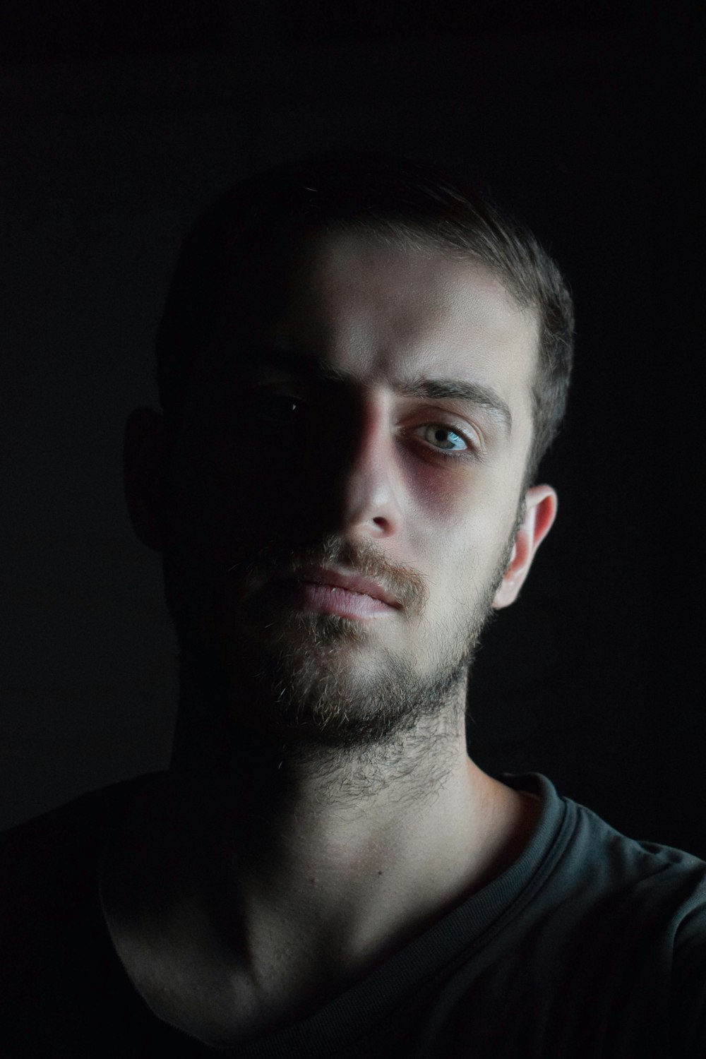 a man in a dark room looking at the camera