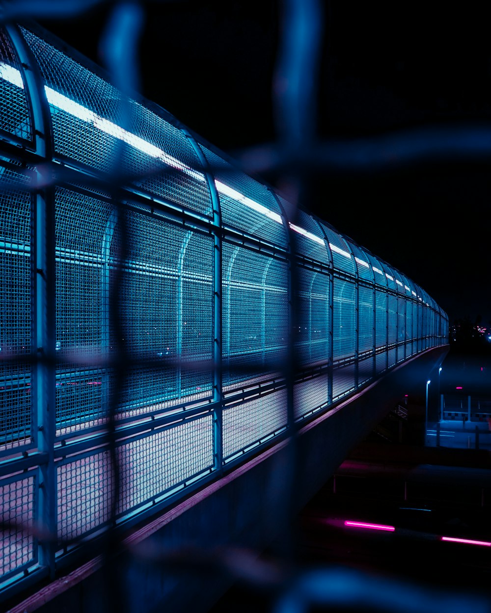 a long metal fence with a building in the background