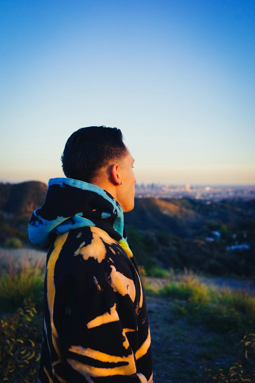 a man standing on top of a lush green hillside