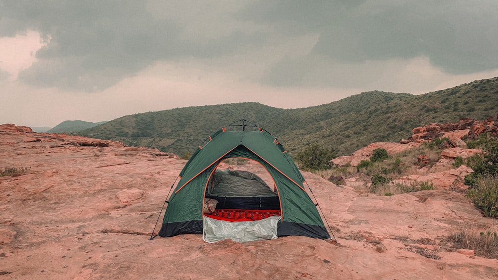 a tent pitched up on a rocky outcropping