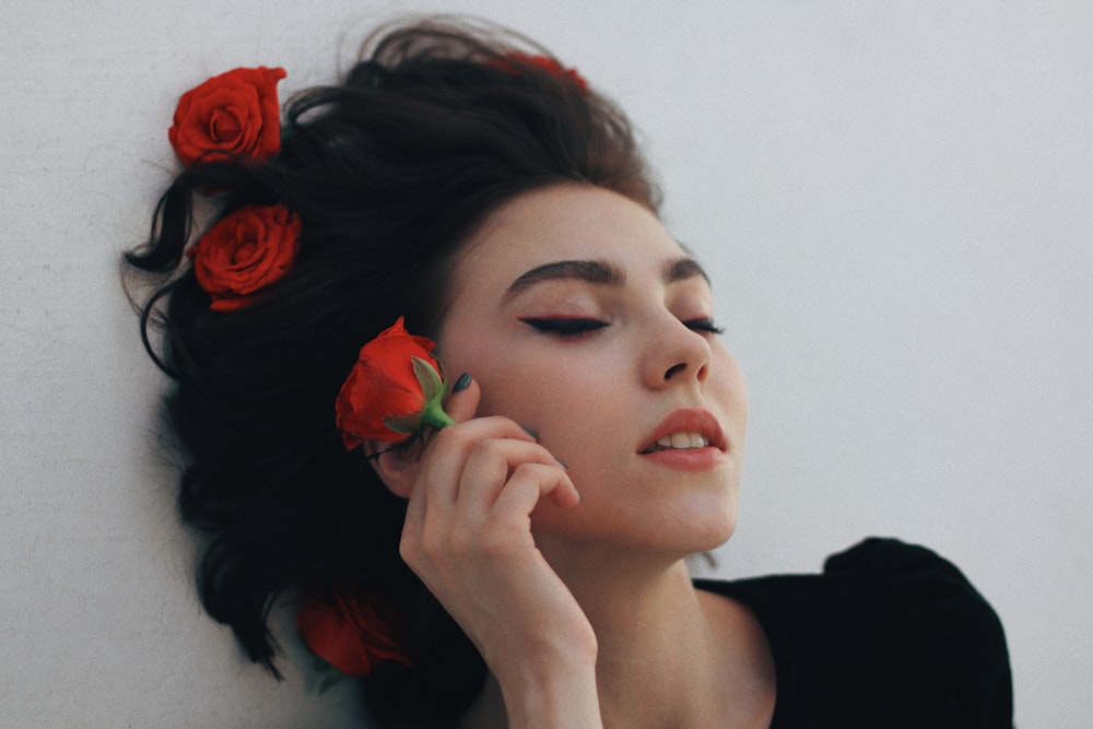 a woman holding a flower in her hair