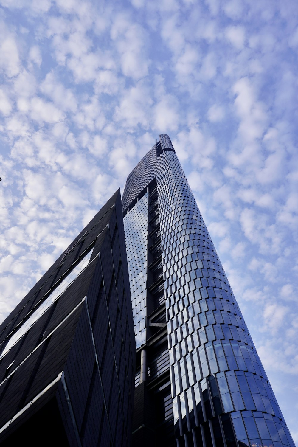 a very tall building with a plane flying in the sky