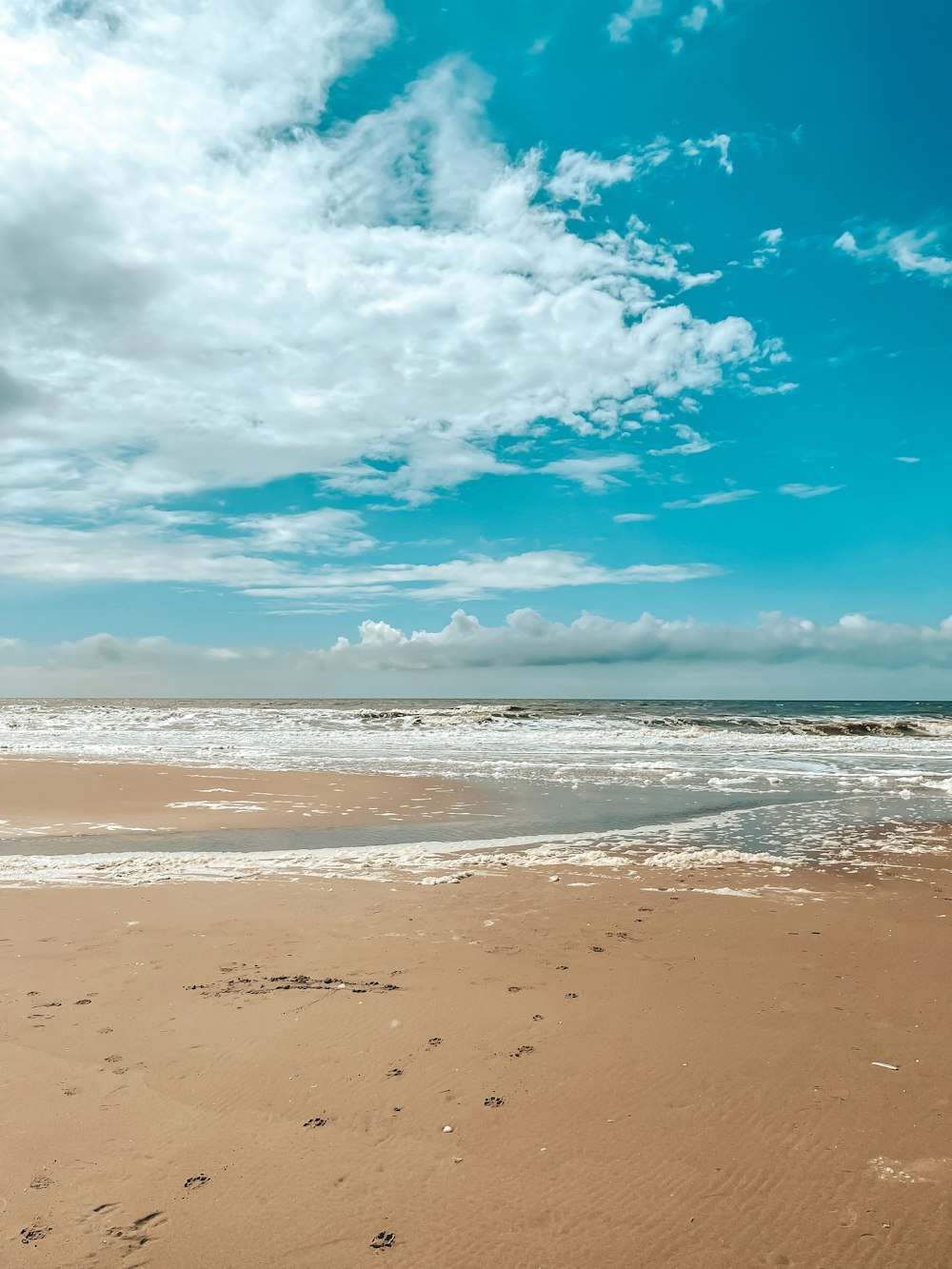 a person walking on a beach with a surfboard