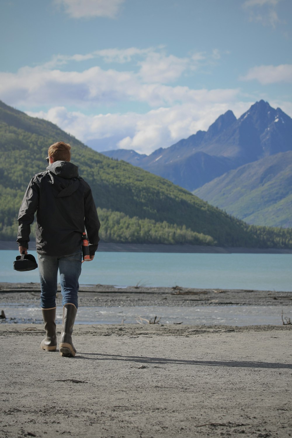 a person walking on a beach with mountains in the background