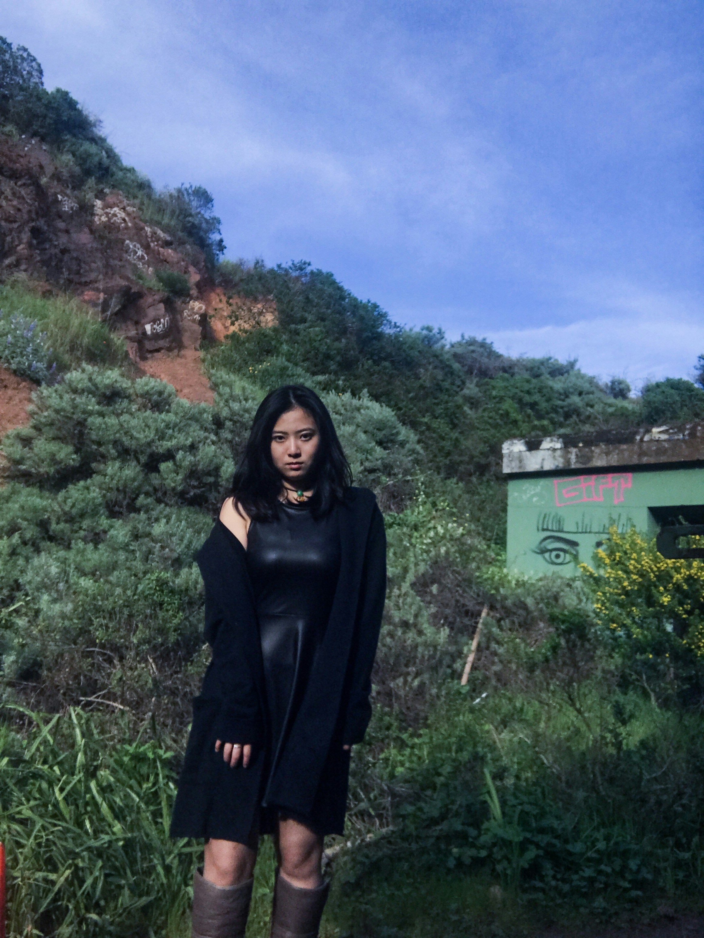 woman in black long sleeve dress standing on green grass field during daytime