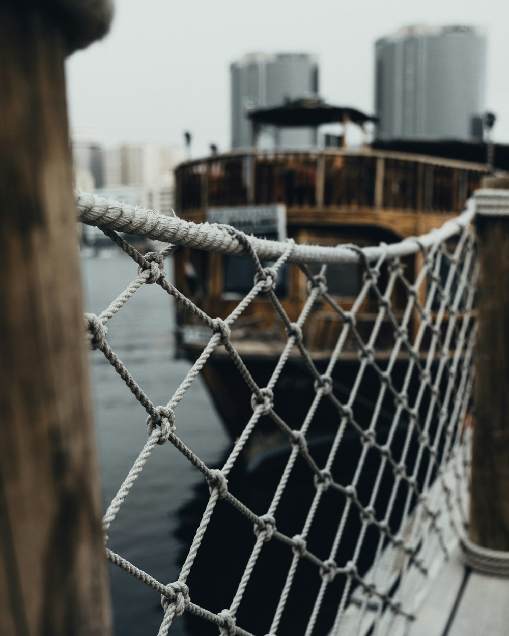 a close up of a fence with a boat in the background