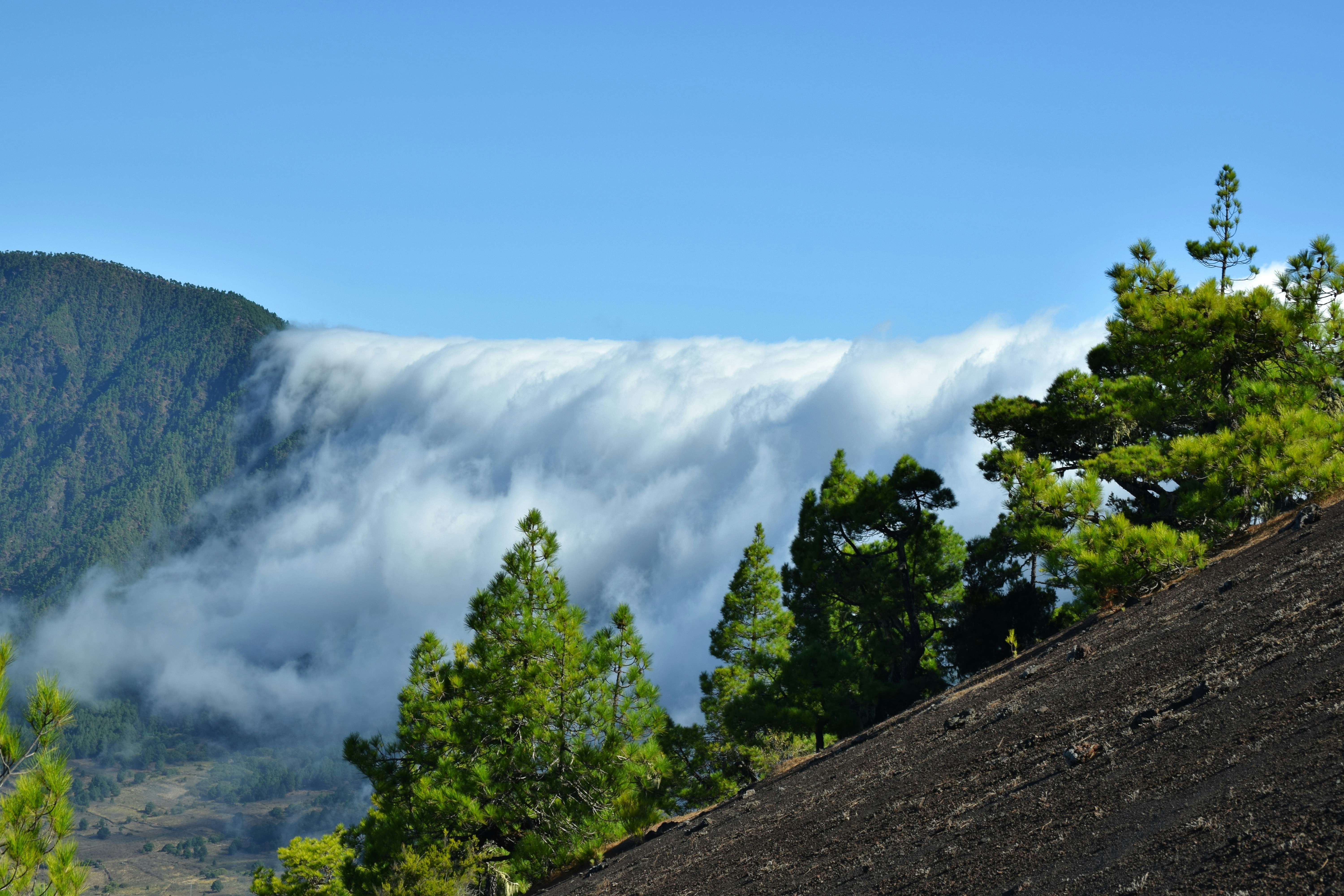Clouds gliding over a mountain into a valley