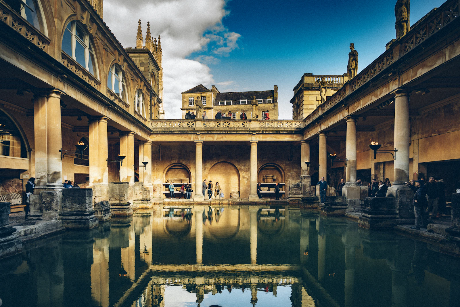 The Great Bath at the Roman Baths in Bath, with the abbey rising behind.