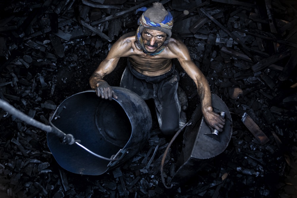 a man with a mask on holding a bucket