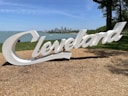a large sign that says cleveland in front of a lake