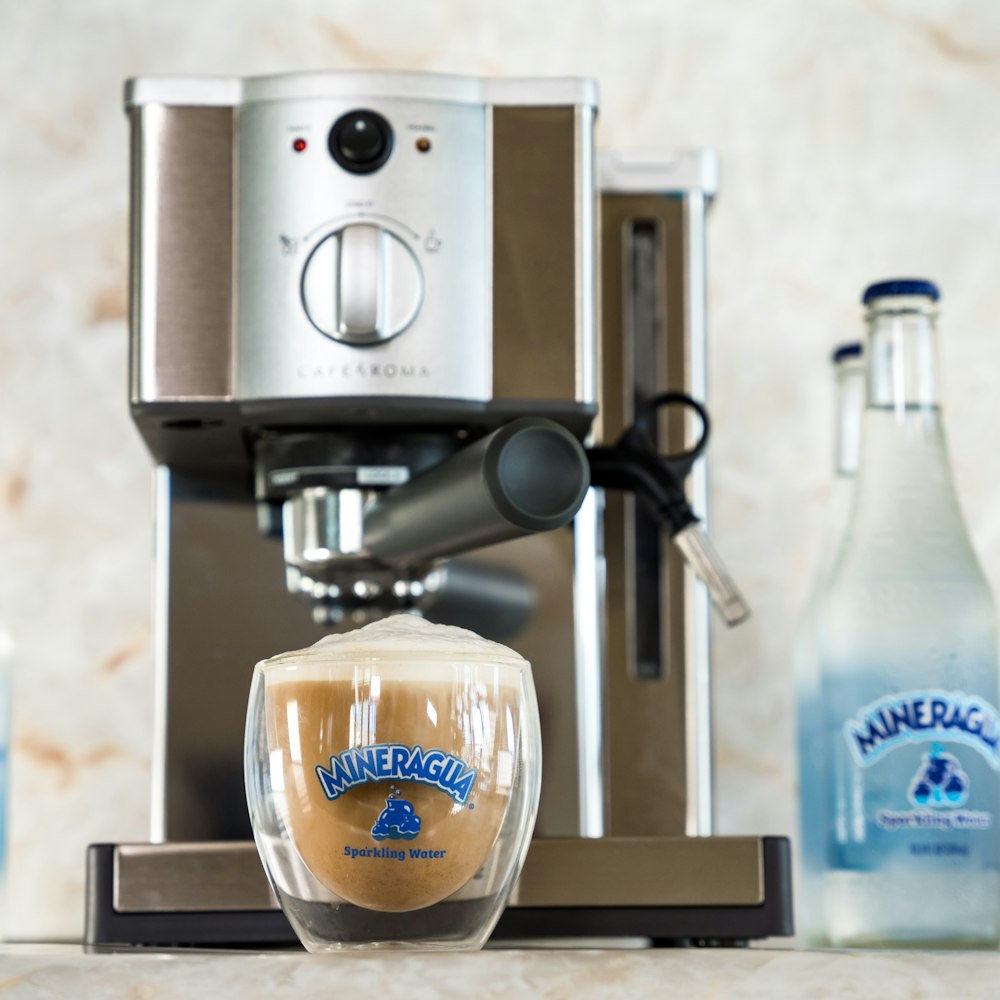 una taza de café junto a una botella de agua