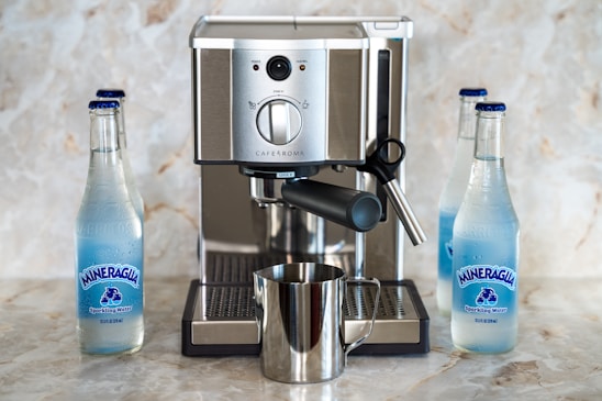 A sleek WaterPro machine filling glass bottles with filtered water in a modern hotel lobby.