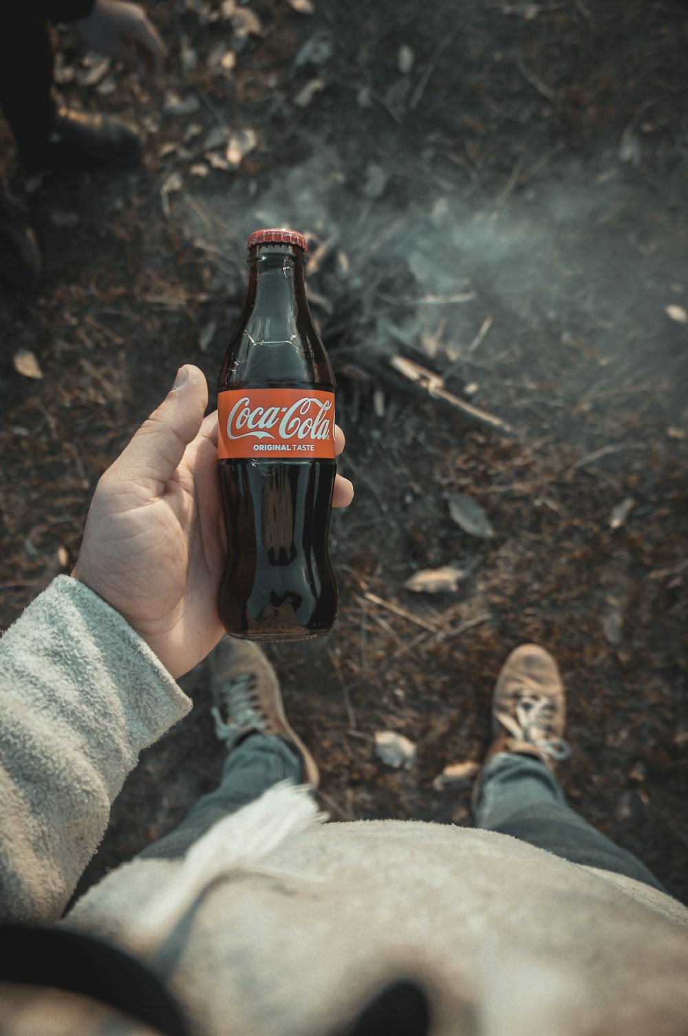 a person holding a bottle of coca cola