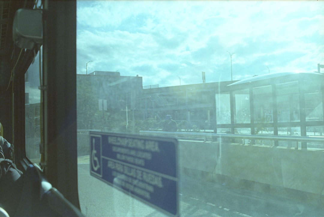 a view from inside a bus looking out the window, JFK/UMASS Red Line Station. Nikon FE2 + Kodak Ektachrome 100 cross-proc