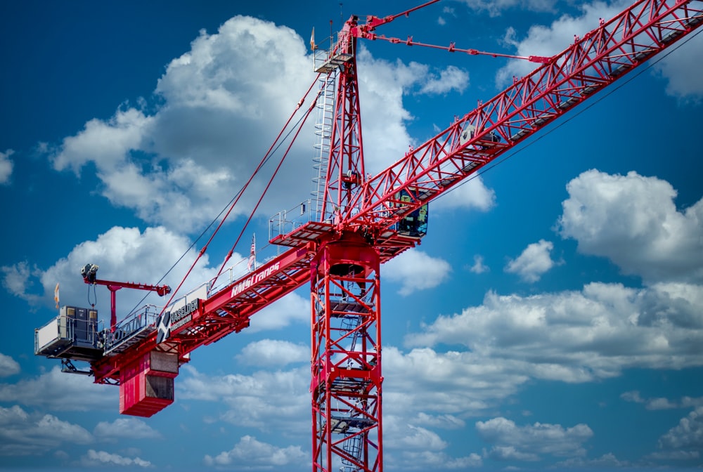 a large red crane sitting on top of a sandy beach