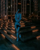 Evening shot of a model in Lumina Apparel standing near illuminated city steps.