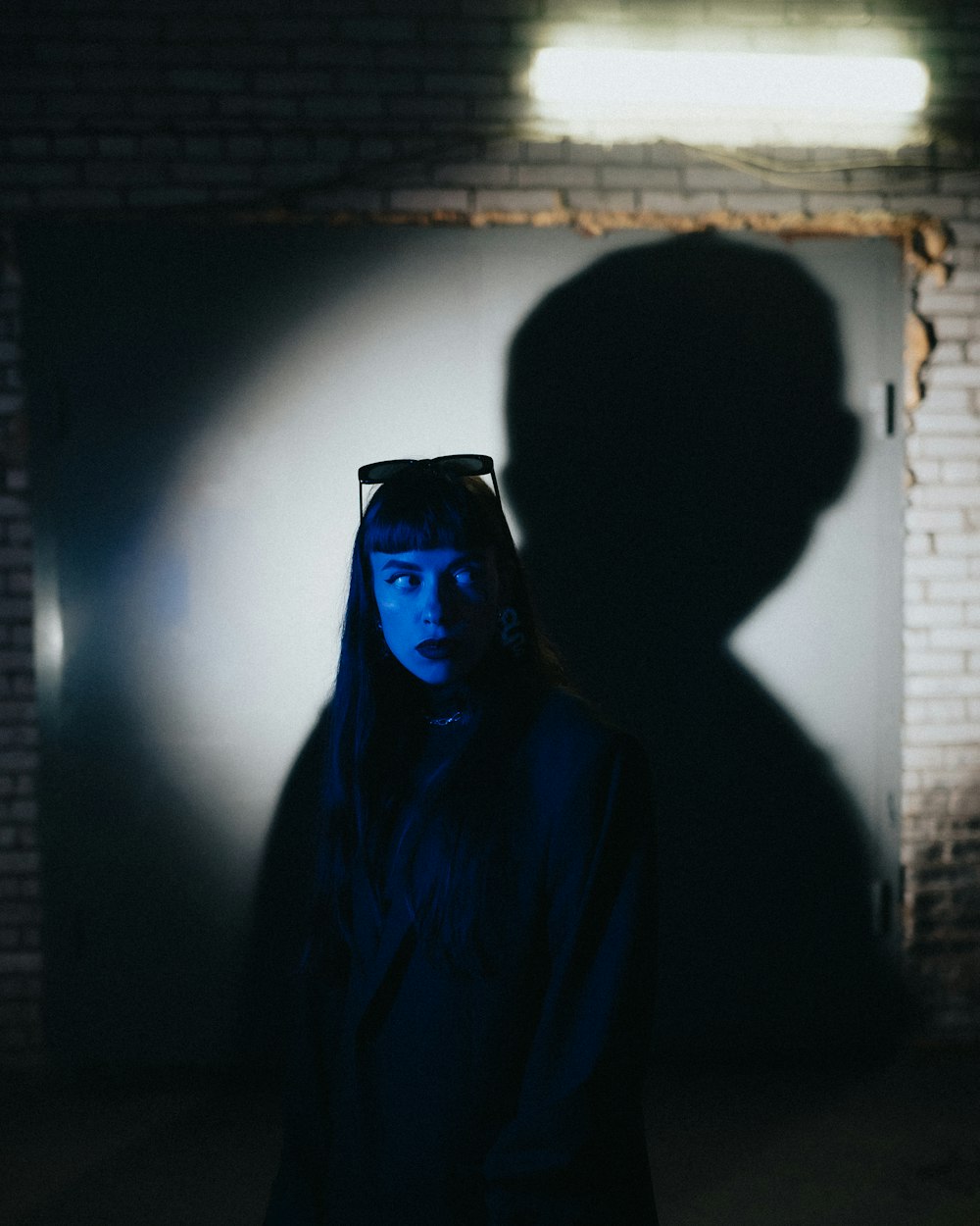 a woman standing in front of a door in the dark