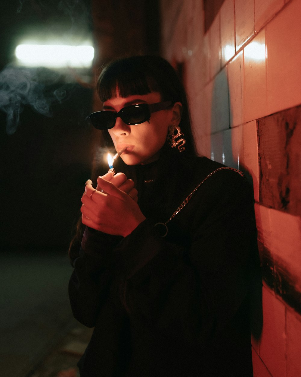 a woman wearing sunglasses and smoking a cigarette