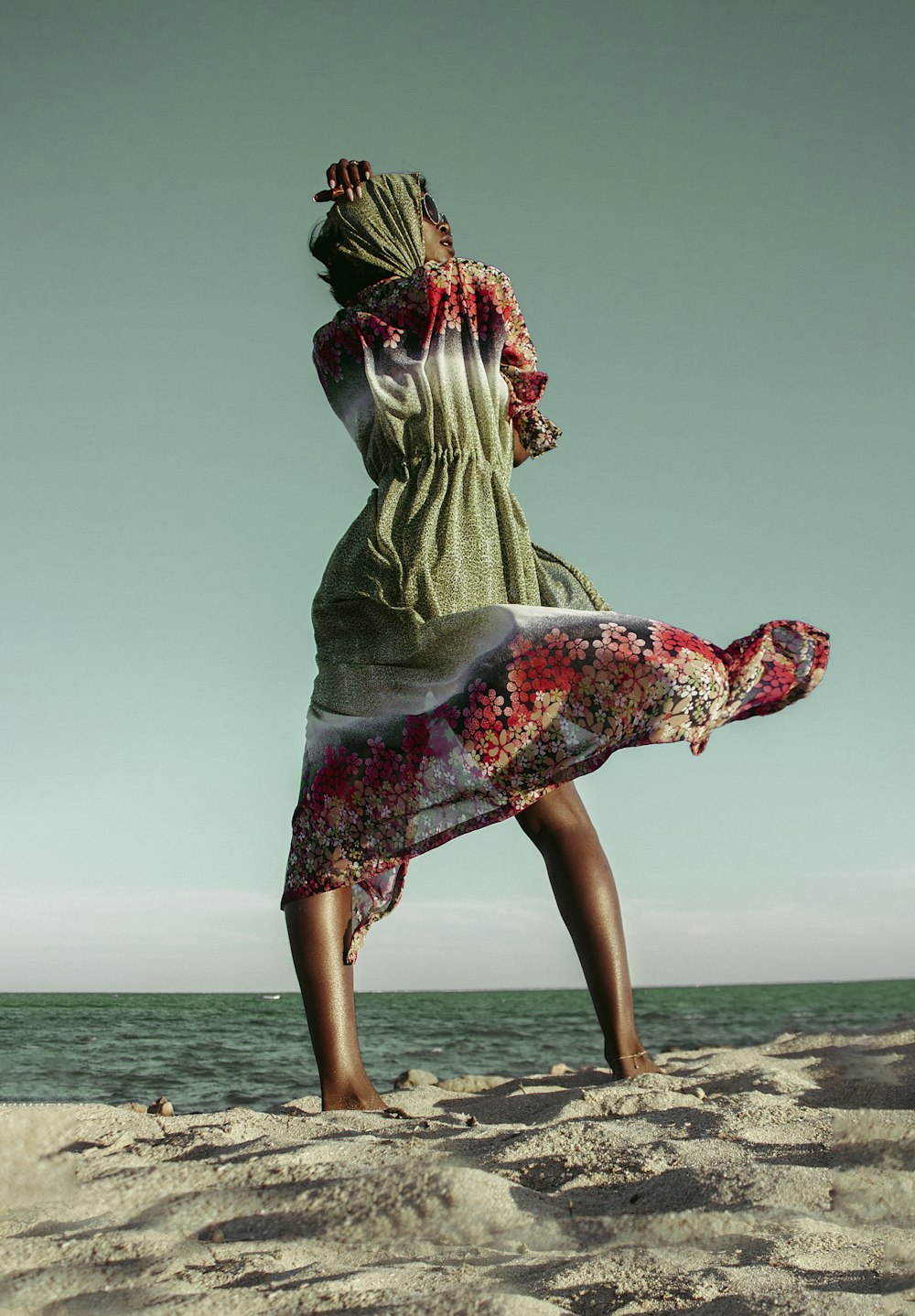 a woman standing on top of a sandy beach