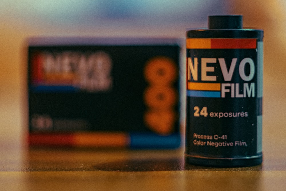 a can of nevo film next to a box of film