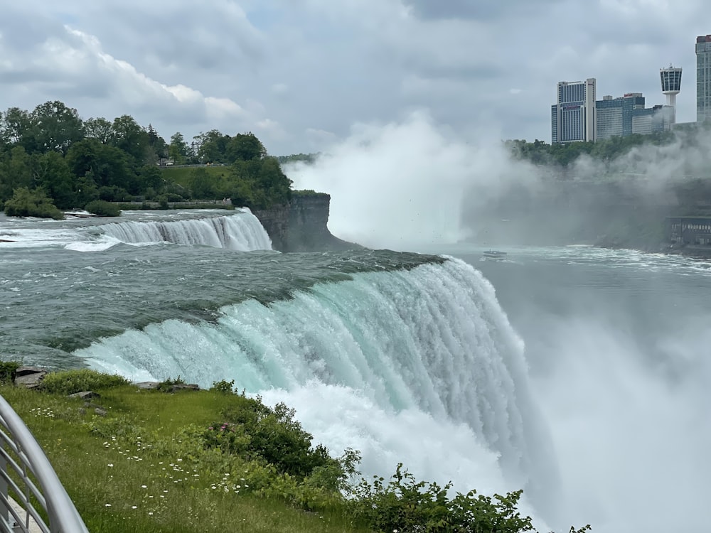 a view of a waterfall with a city in the background