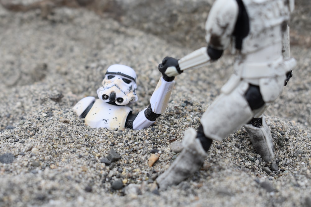 a star wars action figure is in the sand