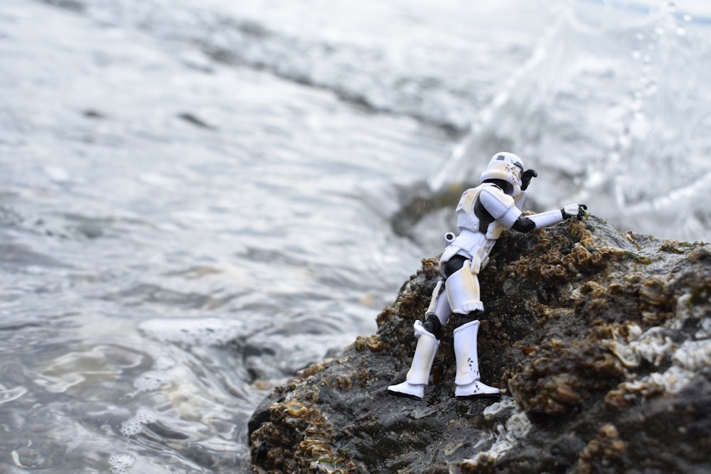 a star wars action figure on a rock in the water