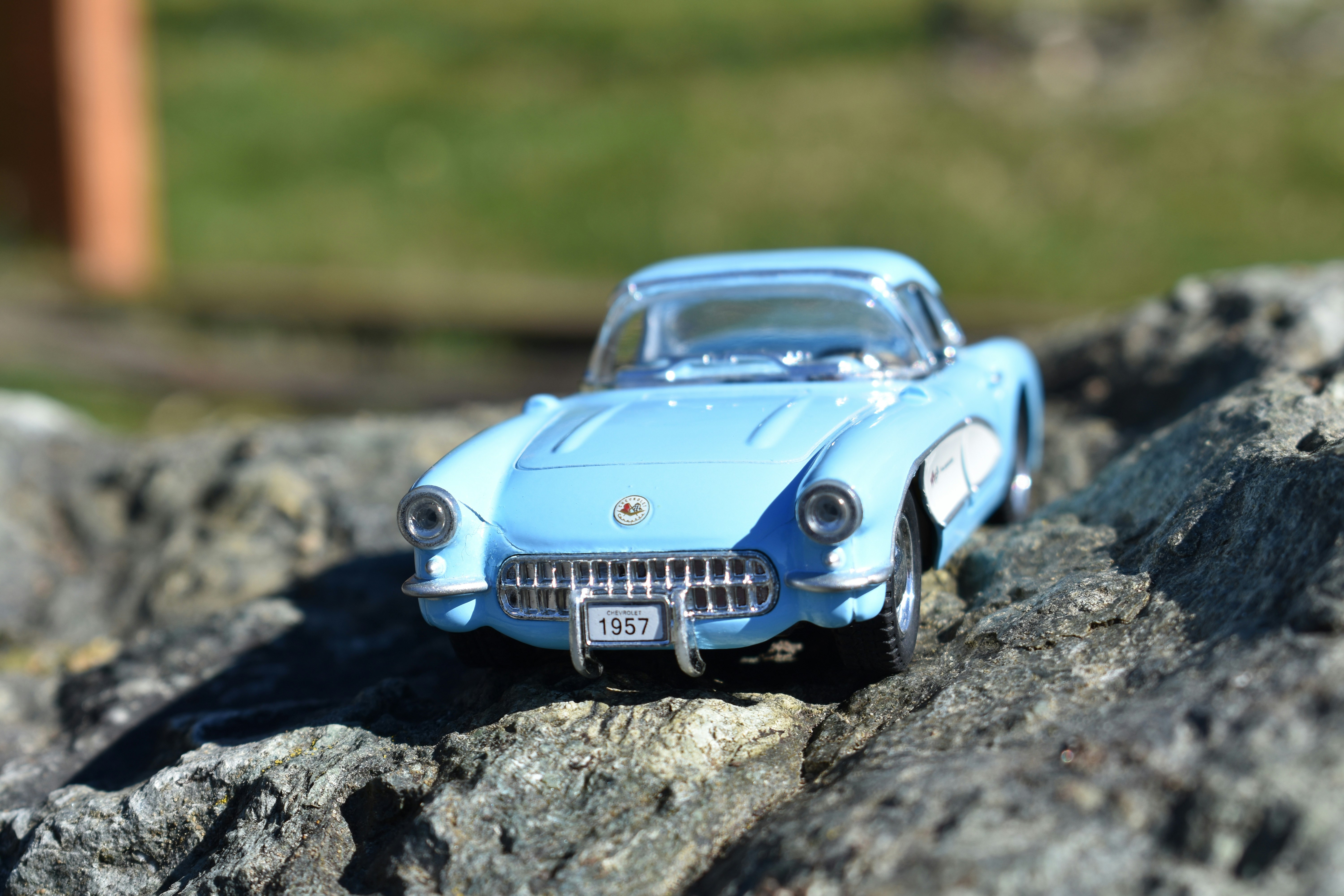 a toy car sitting on top of a rock
