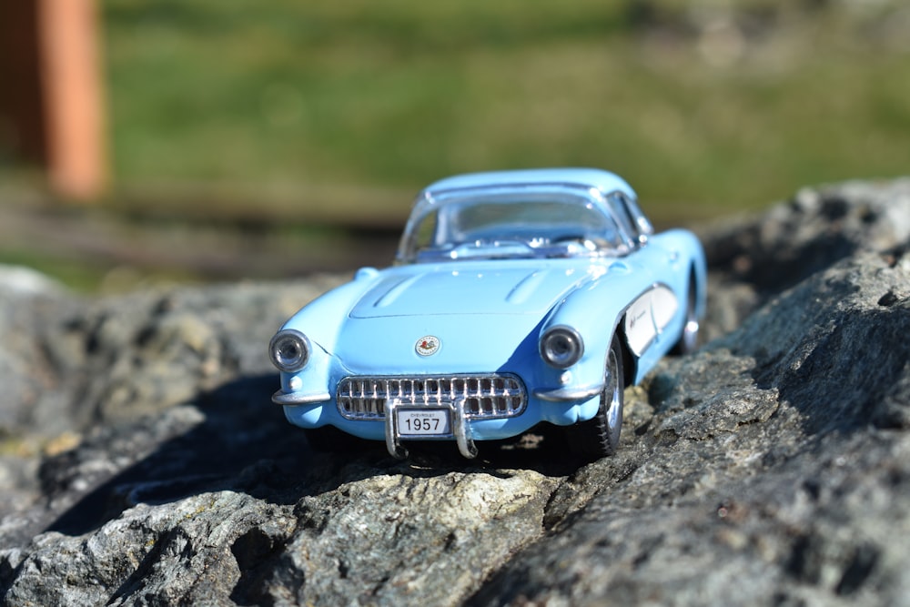 a toy car sitting on top of a rock