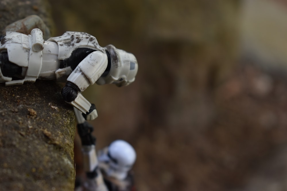 a close up of a star wars action figure on a rock