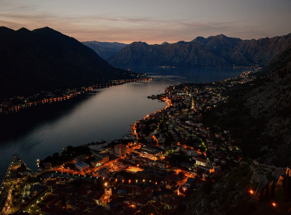 an aerial view of a town and a body of water at night