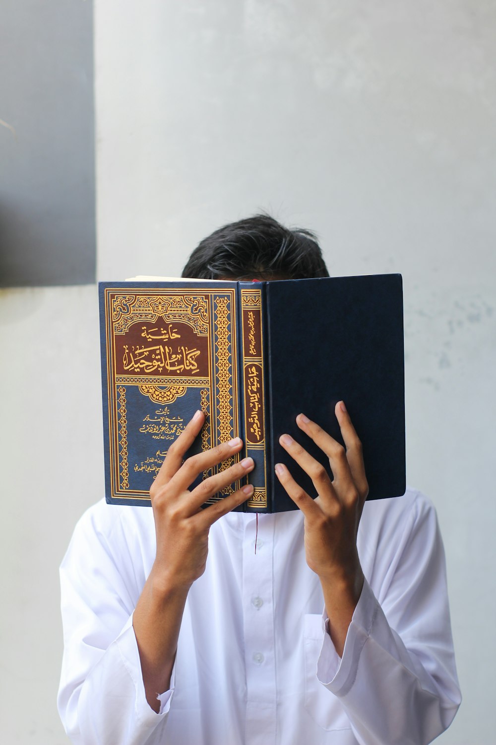 a person holding a book up to their face