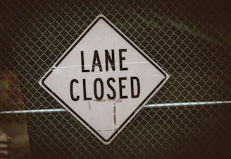 a close up of a street sign on a fence