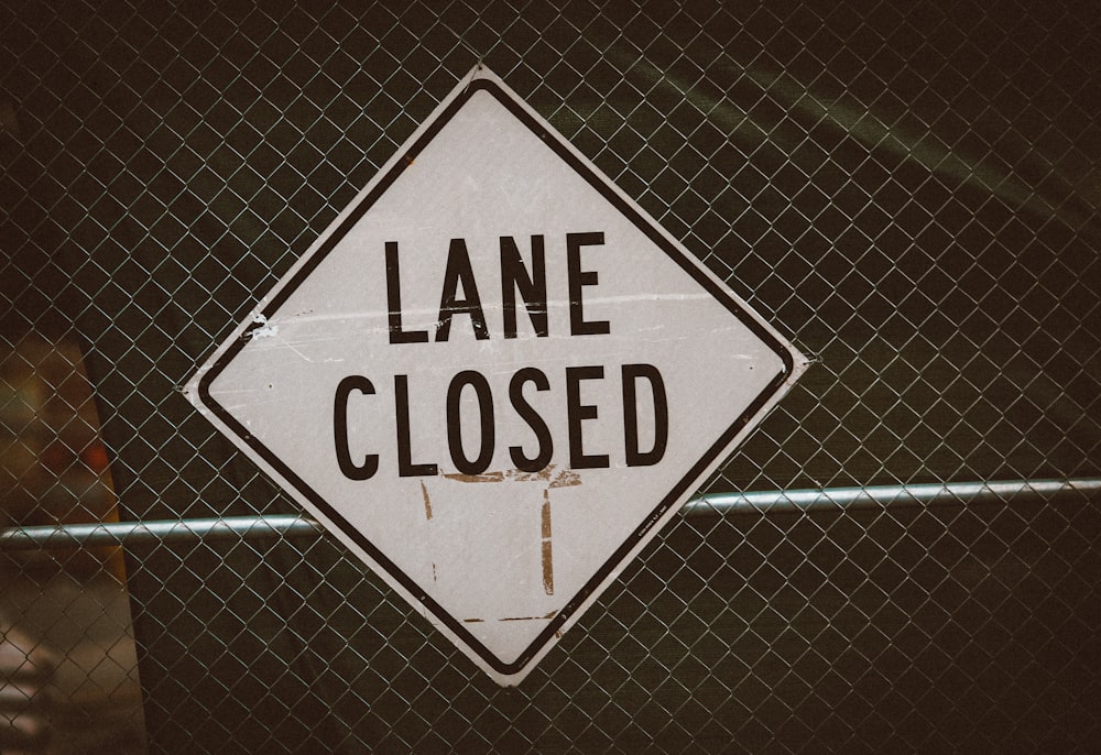 a close up of a street sign on a fence