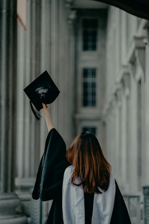 Graduation caps and tassels arranged on a blue background, representing college credit earned early through dual enrollment