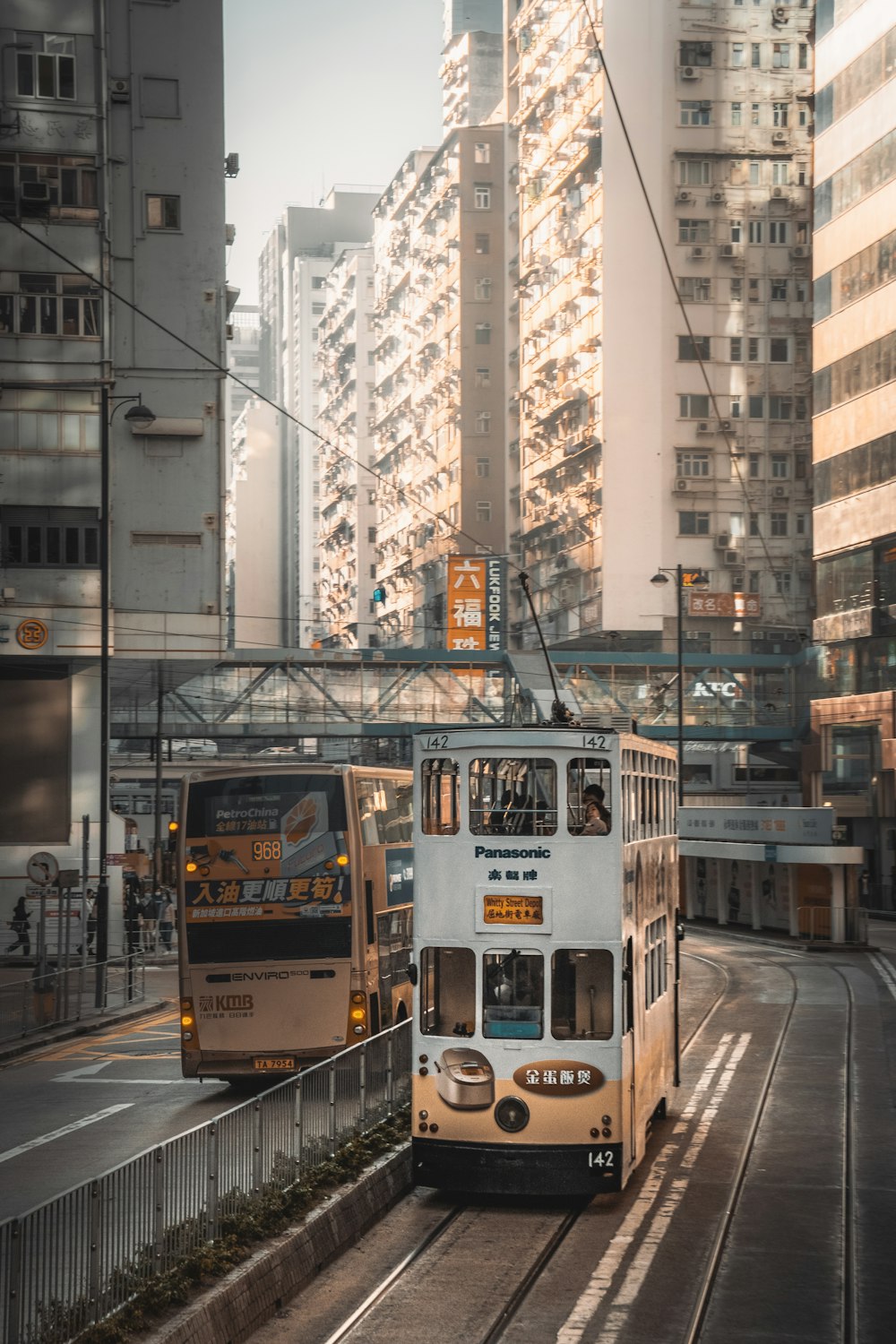 a double decker bus driving down a street next to tall buildings