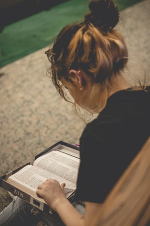 a woman sitting on the floor reading a book