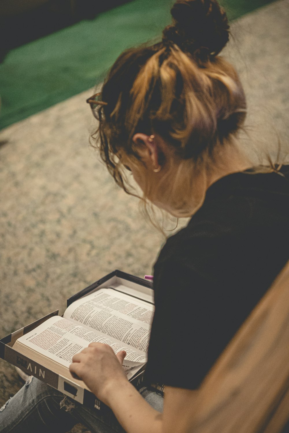 a woman sitting on the floor reading a book