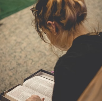 a woman sitting on the floor reading a book