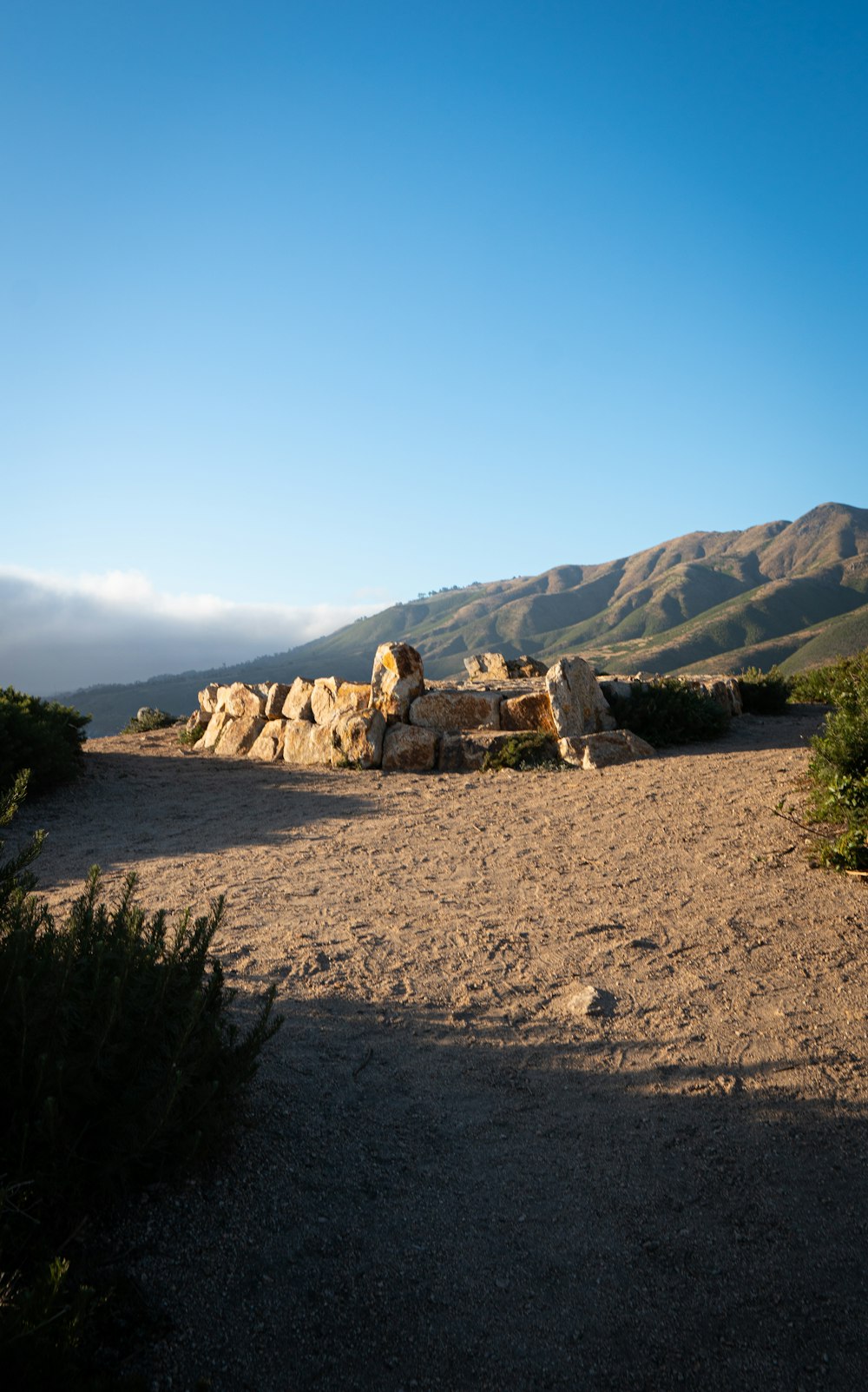 brown rock formation near green trees during daytime