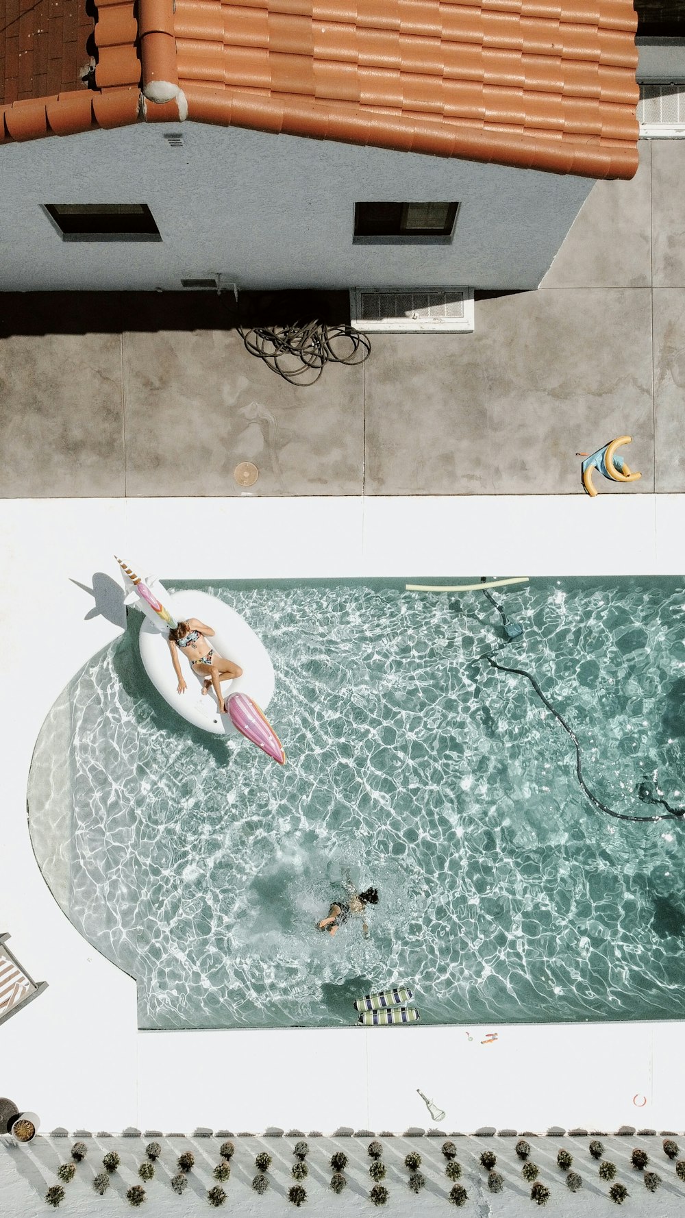 Una mujer montando una tabla de surf encima de una piscina
