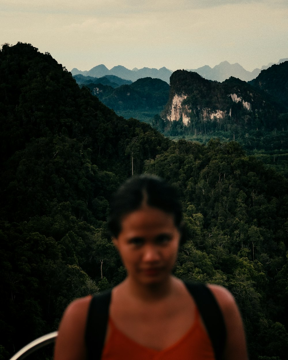 a woman standing in front of a mountain range
