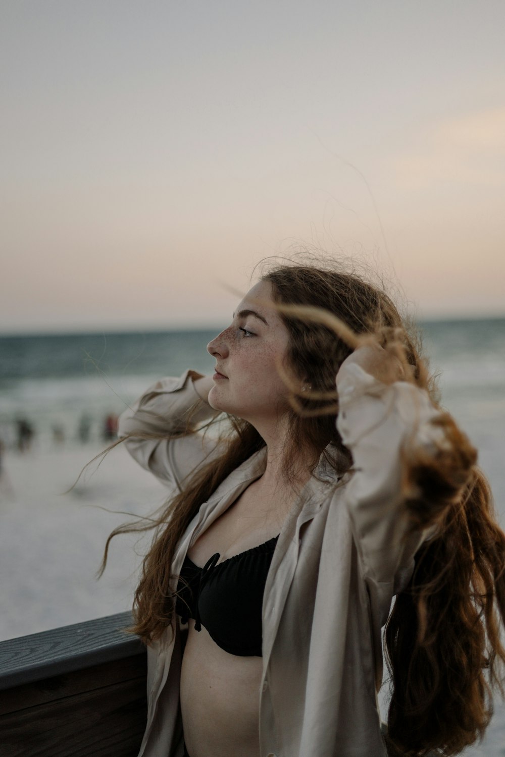 a woman standing on a beach next to the ocean