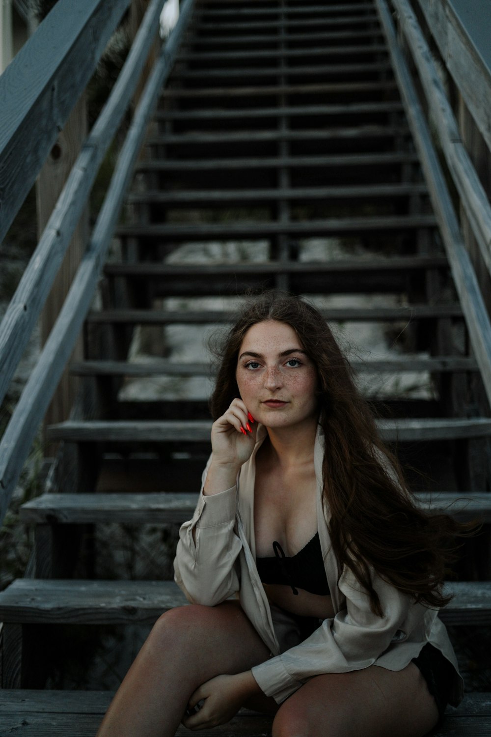 a woman sitting on the steps of a set of stairs