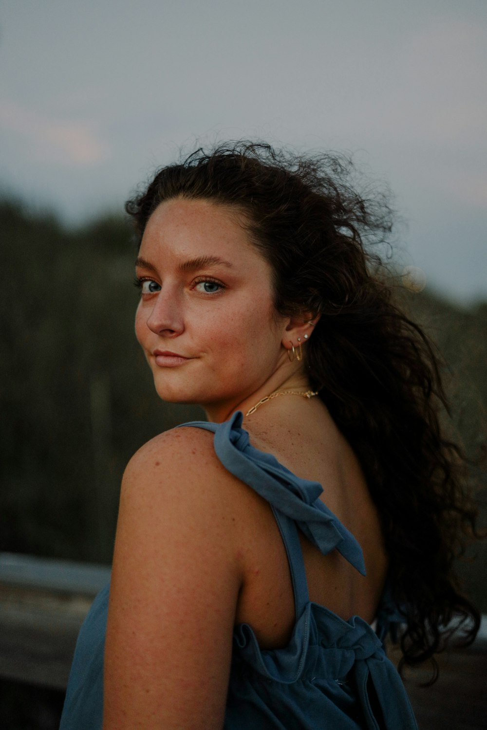 a woman in a blue dress looking at the camera