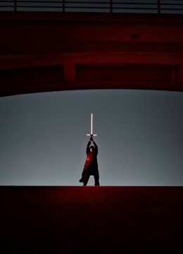 Close-up of a hero character from Skybound Quest wielding a glowing sword against a sunset backdrop.